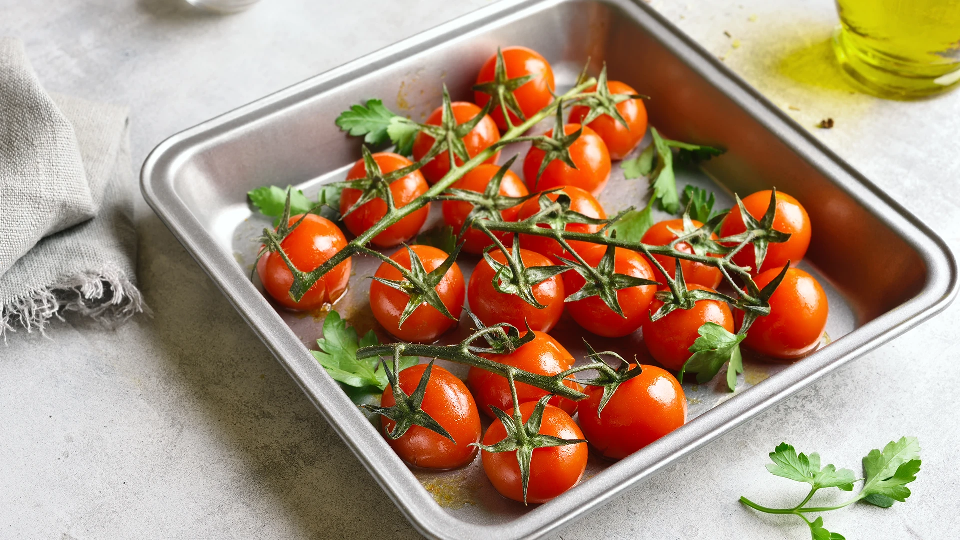 Cherry vine tomatoes in a small square metal tray.