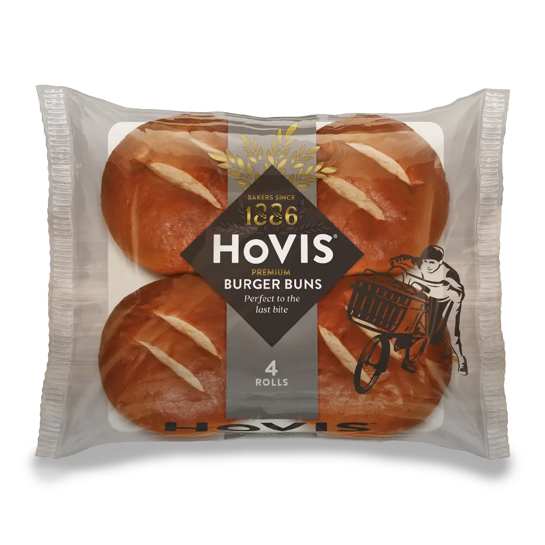 Four Hovis Burger Buns in a transparent square packaging featuring the Boy on the Bike, a grey stripe, golden wheat, and the Hovis logo on top.
