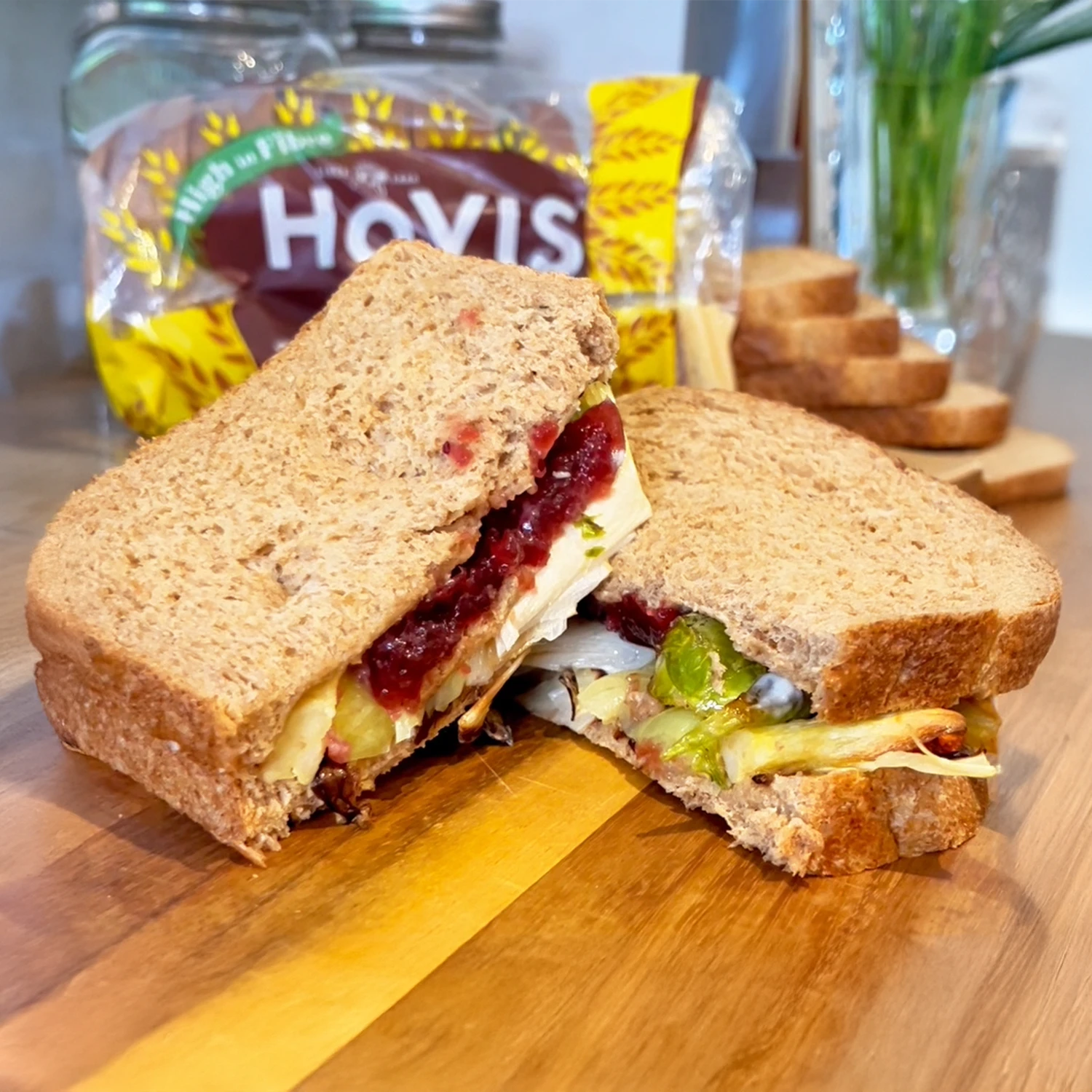 Two Hovis Tasty Wholemeal Medium Sliced sandwiches filled with turkey, cranberry, pigs in blankets, carrots and brussel sprouts.