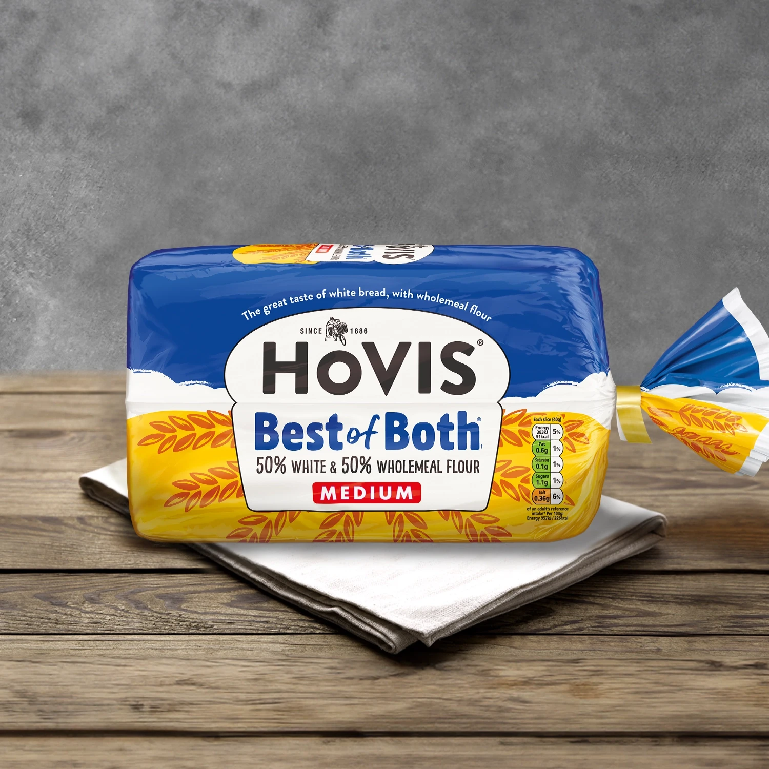 A Hovis best of both loaf sits on a table cloth on a wooden table