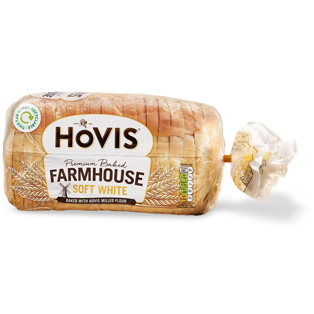 Hovis Farmhouse Soft White bread with a subtle shadow under it. The packaging is transparent, decorated with wheats.