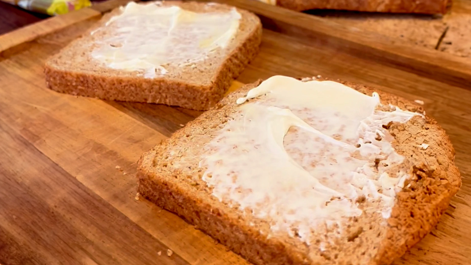 Two slices of Hovis Tasty wholemeal covered in a layer of butter and mayonnaise on both slices.